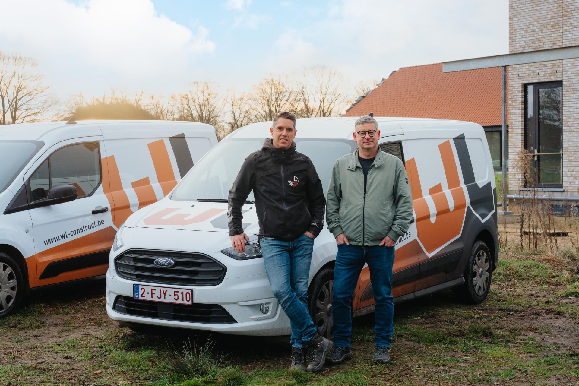 Karel Wynants en Marin Lamer leunen op een wagen van WL Construct.